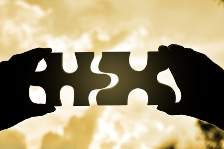 hand holding wood jigsaw piece texture pattern on nature backgroundの写真素材