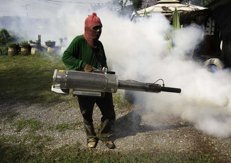Man work fogging to eliminate mosquito for preventing spread dengue fever in Thailand.