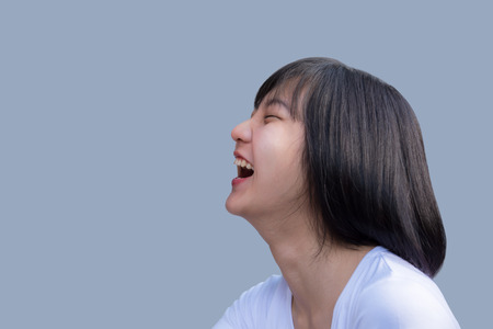 laughing woman with clean skin, and white teeth portrait on grey backgroundの写真素材