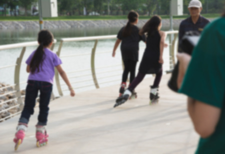 Blurred young people playing roller skates outdoor in park. Teenage girls on roller skates at outdoor.の写真素材