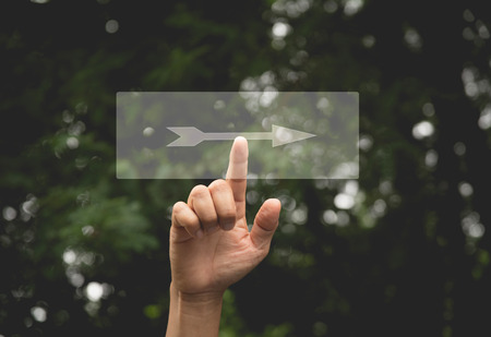 Hand of person presses button right arrow. Hand pressing on virtual screen and selecting button right arrow.の写真素材