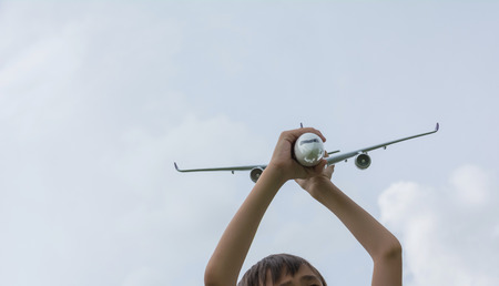 Kid playing with toy airplane. Kids playing with toy airplane at the day time. Kid having fun outdoors.の写真素材