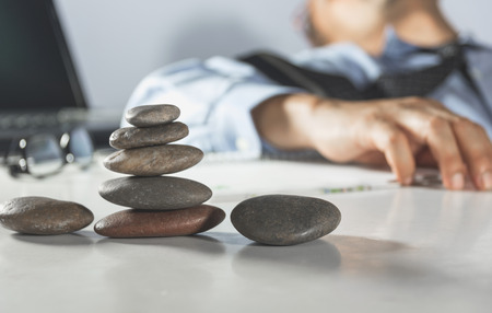 Businessman keeping eyes closed while sitting at his working place in office. Feeling sick and tired concept.の写真素材
