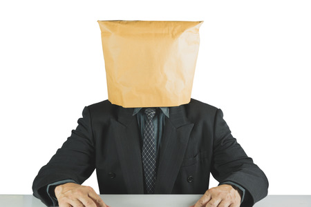 Businessman wearing brown paper bag isolated on white background. Businessman with a paper bag on head.の写真素材