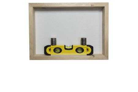 Yellow building level, balance ruler with stack coins in wooden frame isolated on a white...