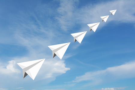 Paper airplane as a leader among another airplane , leadership, teamwork on blue sky background.の写真素材