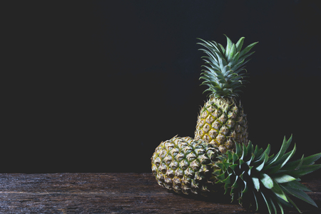 Fresh pine apple, vitamin and good for health on wooden table with black background.の写真素材