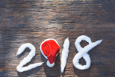 2018 Happy new year numbers with cotton and Santa Claus red hat on wooden backgroundの写真素材