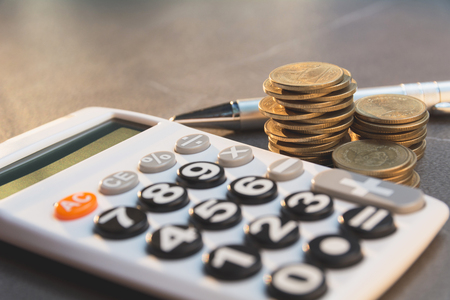 Saving money concept with money coin stack growing and calculator for business and accounting concept.の写真素材