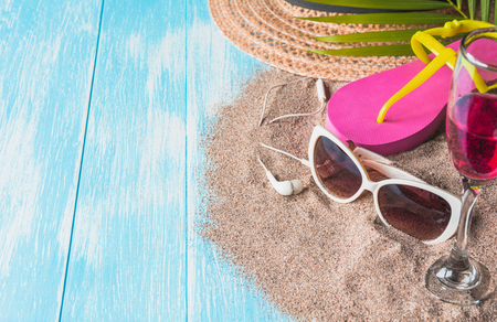 Travel equipment, eyeglasses with sandals and sun hat on blue wooden background. Copy space for creative design text and word.の写真素材