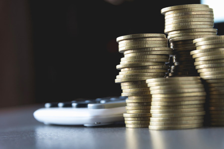 Saving money concept with money coin stack growing and calculator for business and accounting concept.の写真素材