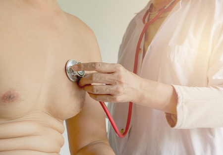 Female doctor using stethoscope for check and listen to heart and lungs of patient at a hospital.の写真素材