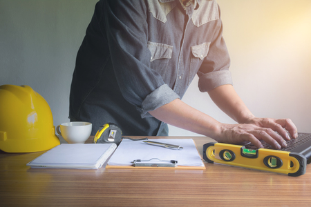 Architect engineer working concept with laptop and construction tools or safety equipment on table.の写真素材