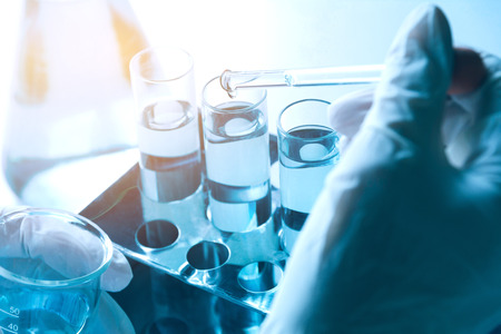 Researcher with glass laboratory chemical test tubes with liquid for analytical , medical,...