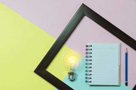 Top view of pencil with light bulb and notebook on colorful background and copy space for insert text.の写真素材