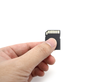 Hand holding a memory card isolated on white background.