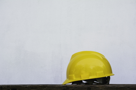 Construction Helmet, yellow safety helmet on wooden table.の写真素材