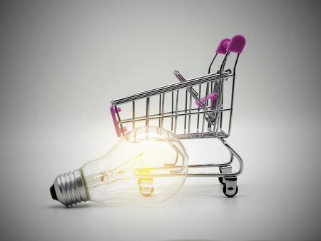 Light bulb in the shopping cart on white background. Saving energy and business concept.の写真素材