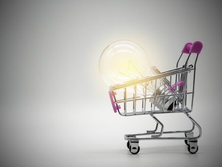 Light bulb in the shopping cart on white background. Saving energy and business concept.の写真素材