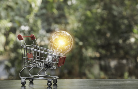 Energy saving light bulb with shopping cart financial and shopping concept and copy space for insert text.の写真素材