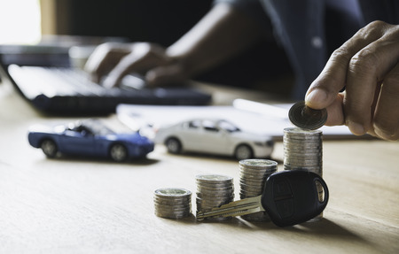 Car insurance and car service with stack of coins. Toy car for accounting and financial concept.
