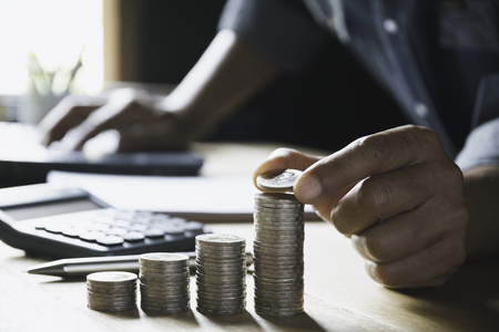 Hand drop a coin with money coin stack growing for business. financial and accounting concept.の写真素材