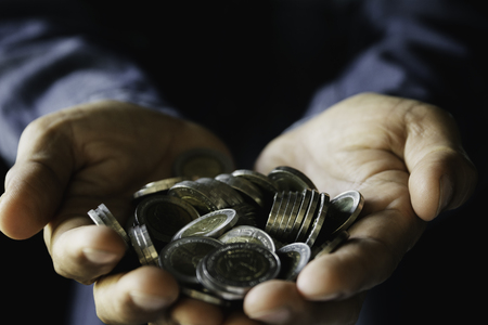 Hand holding money gold coins with plant in hand for financial and saving money concept.の写真素材