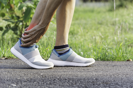 The female clings to a bad leg. The pain in her leg. Health and painful concept.の写真素材