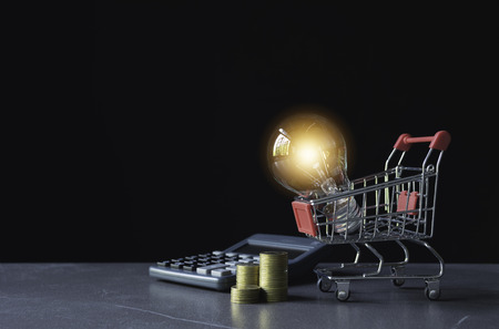 Energy saving light bulb with shopping cart financial and shopping concept and copy space for insert text.の写真素材