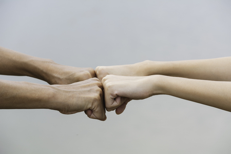 Friend fist bump together at outdoor. Fist bump between colleagues. Friendship and teamwork concept.の写真素材