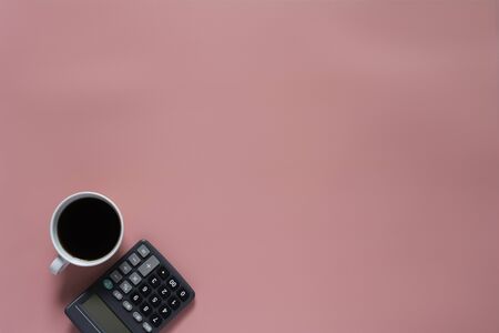 Top view of coffee with calculator on pink background and copy space for insert text.の写真素材