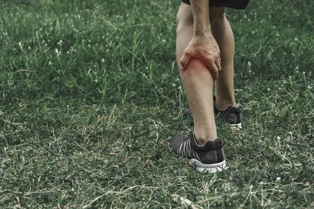 A man clings to a bad leg. The pain in her leg. Health and painful concept.の写真素材