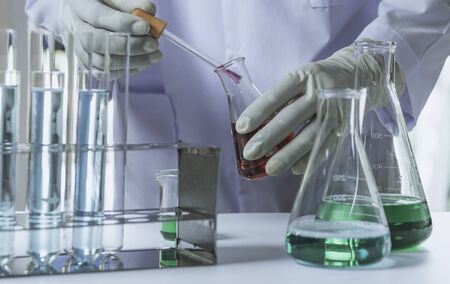 Researcher with glass laboratory chemical test tubes with liquid for analytical , medical, pharmaceutical and scientific research concept.の写真素材