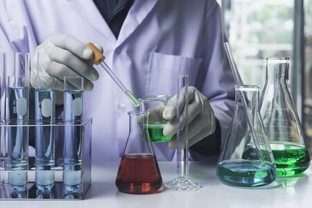Researcher with glass laboratory chemical test tubes with liquid for analytical , medical, pharmaceutical and scientific research concept.の写真素材