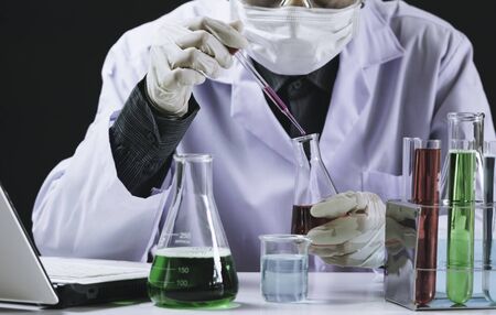 Researcher with glass laboratory chemical test tubes with liquid for analytical , medical, pharmaceutical and scientific research concept.の写真素材