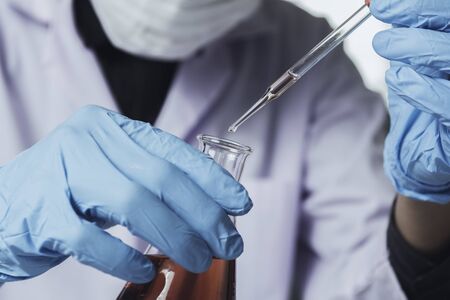 Researcher with glass laboratory chemical test tubes with liquid for analytical , medical, pharmaceutical and scientific research concept.の写真素材