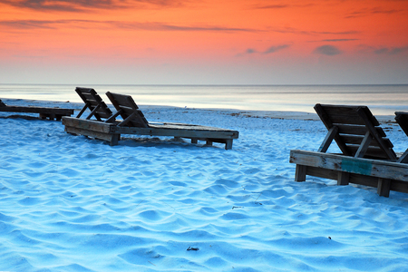 Wooden chairs await relaxers along the Gulf of Mexico Shore in Pensacola, Floridaの写真素材