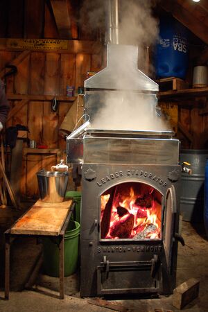 A natural wood flame fire heats the pure maple sap, the beginning process to make pure maple syrupのeditorial素材
