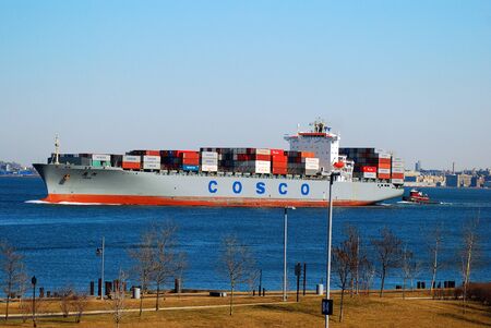 A COSCO cargo ship cruises the Kill Van Kull, between Staten Island and Bayonne, NJ, on its way to Port Newarkのeditorial素材