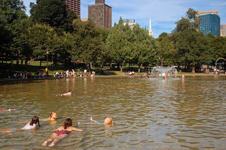 Children cool off on a warm summer day at the Frog Pond in Boston Common