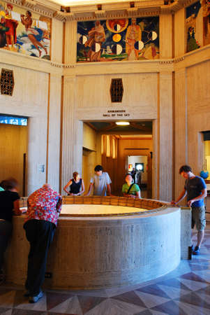 People watch the Foucault Pendulum in the lobby of the Griffith Observatory in Los Angelesのeditorial素材