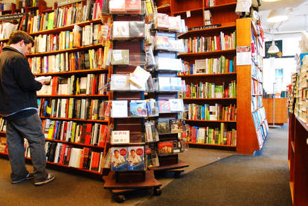 A young man Browses for books at the Harvard Book Store in Cambridgeのeditorial素材