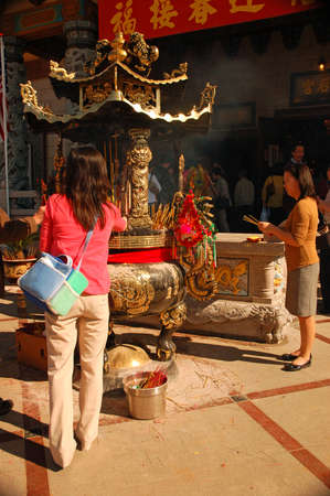 Two asian women offer prayers during a Chinese New Year celebration in Los Angelesのeditorial素材