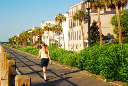 A young woman takes a walk along the waterfront Prominade, in Charleston, South Carolinaのeditorial素材