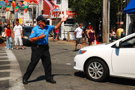 A traffic cop performs dance moves as he directs cars through downtown Provincetown, Ca[pe Cod, Massachusettsのeditorial素材
