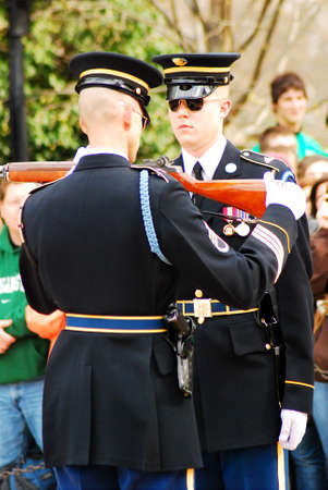 An honor guard has his rifle inspected before guarding the tomb of the Unknown Soldier in Arlington...