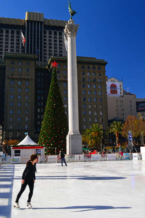A young woman ice skates during the Christmas season in Union Square in San Franciscoのeditorial素材