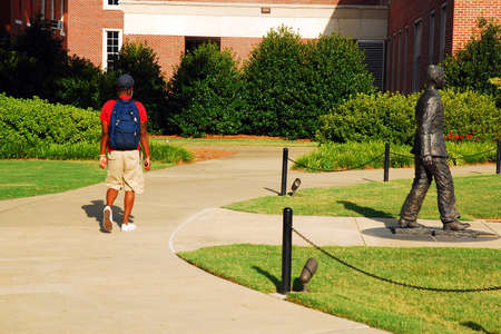 An African American student walks by the James Meredith Statue, honoring the first black student to attend the University of Mississippi.のeditorial素材