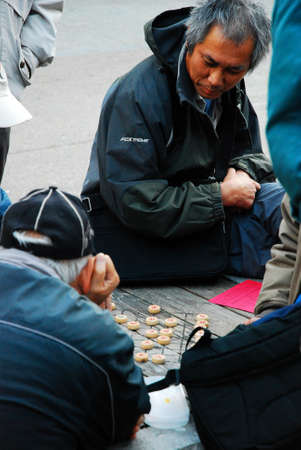 Senior men enjoy a game of xiangqi in San Franciscoのeditorial素材