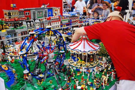 An adult man makes a quick repair on his Lego display at a convention in Fairfax, Virginiaのeditorial素材